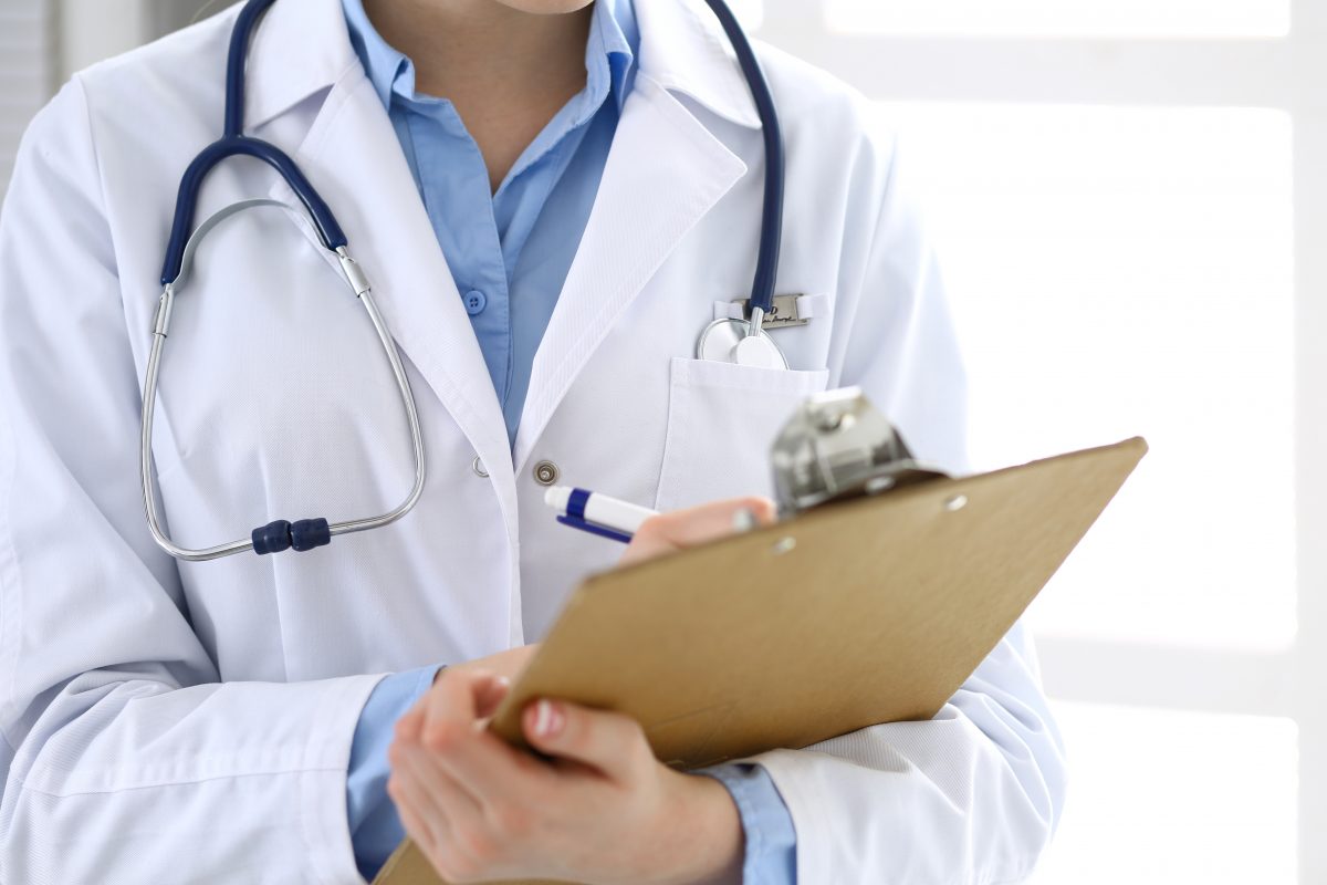 Female doctor filling up medical form on clipboard closeup. Healthcare, insurance and medicine concept